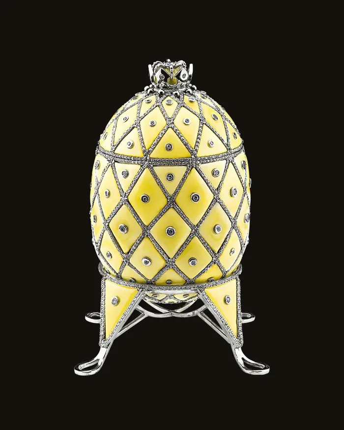 Gold egg in yellow enamel set with diamonds, standing on its own gold stand